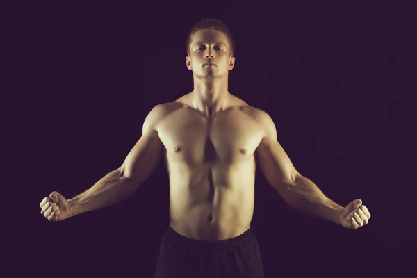 Gesunder muskulöser junger Mann posiert im Studio — Stockfoto