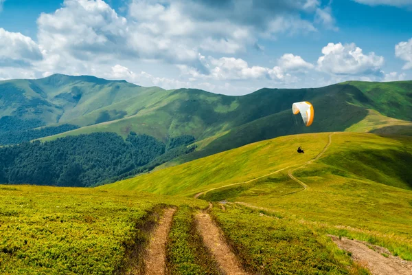 Пейзаж з хмарами в горах, парапланер, парашут, слайдер Ліцензійні Стокові Зображення