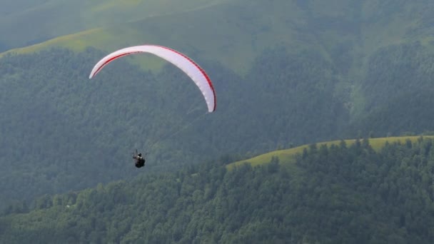 Parapente volando alto en las montañas — Vídeo de stock