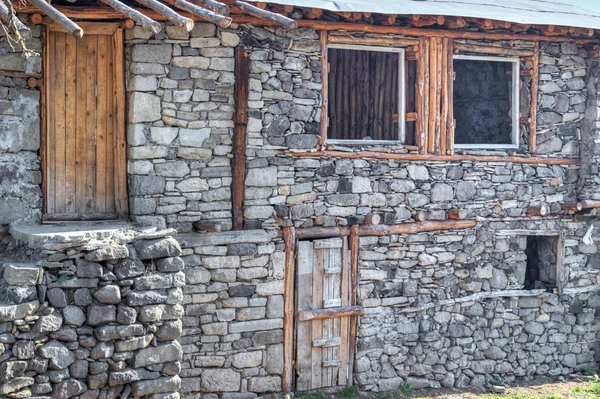 Casa de pedra inacabada com porta de madeira e janelas — Fotografia de Stock