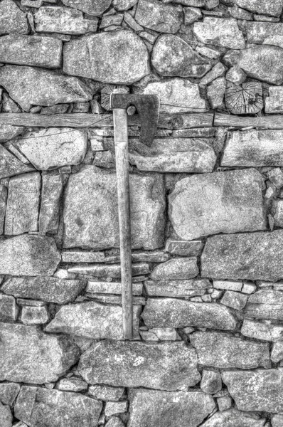 Stone wall background and axe in black and white — Stock Photo, Image