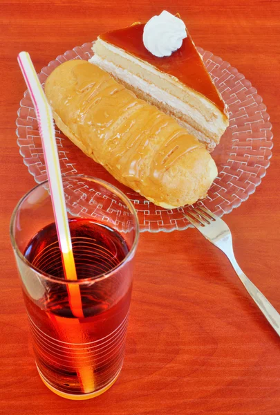 Kuchen, Eclairs und Saft auf dem Tisch — Stockfoto