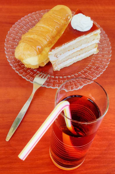 Kuchen, Eclairs und Saft auf dem Tisch — Stockfoto