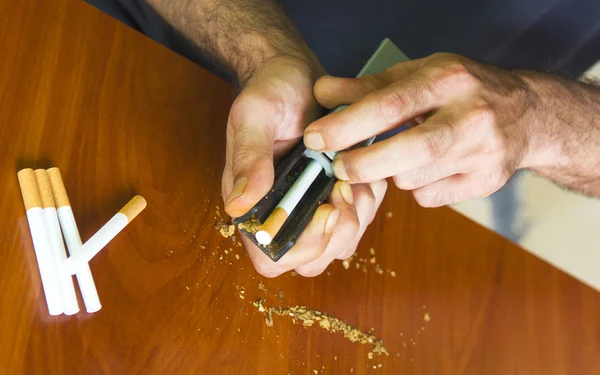 Homem enrolando cigarros usando tabaco fresco — Fotografia de Stock