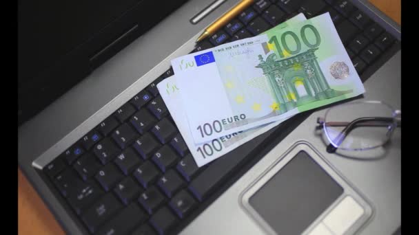 Geld op een laptop toetsenbord — Stockvideo