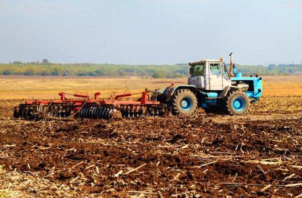Farmer in tractor preparing land — Stock Photo, Image