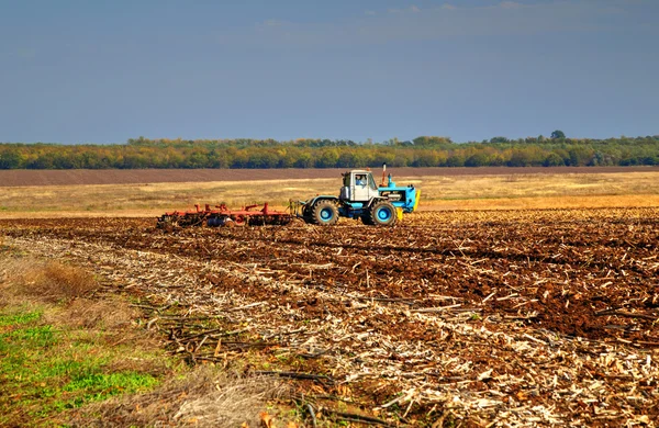 Farmer in tractor preparing land — Stock Photo, Image