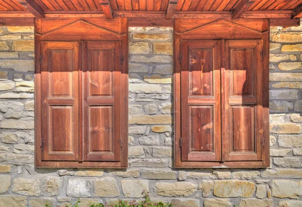 Stijlvolle houten ramen op stenen muur — Stockfoto