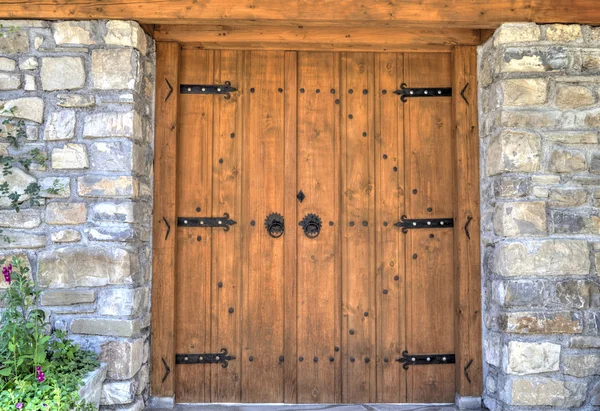 Porte en bois élégante avec des ornements métalliques sur le mur de pierre — Photo