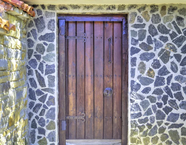 Κομψή ξύλινη πόρτα στον πέτρινο τοίχο — Φωτογραφία Αρχείου