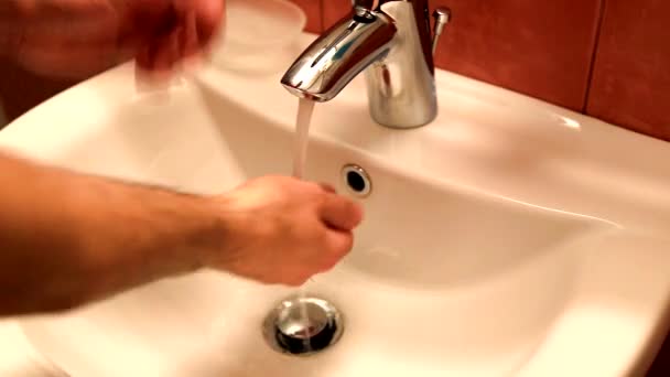 Мужчина моет руки на раковине в ванной — стоковое видео