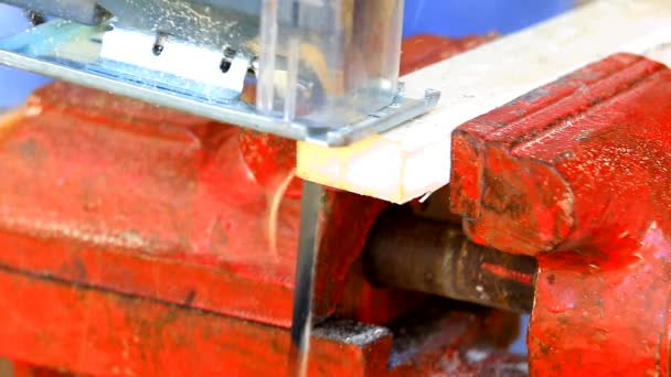 Scie sauteuse découpant une planche en bois 