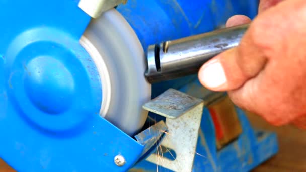 Worker grinding metal component on bench grinder — Stock Video