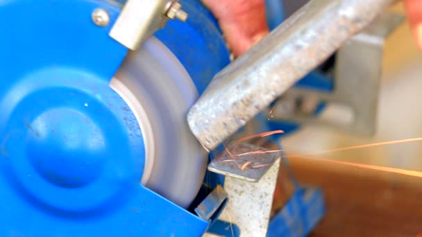 Worker grinding metal component on bench grinder — Stock Video