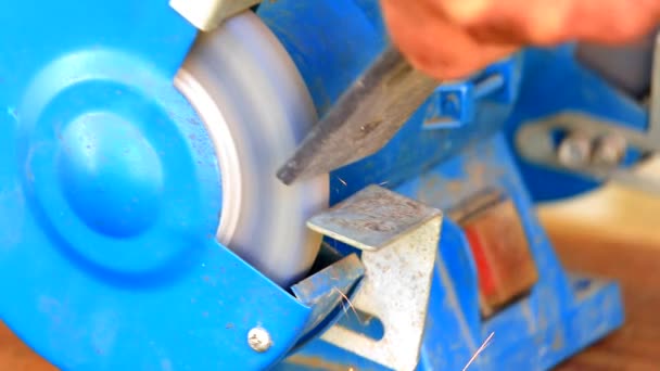 Worker grinding metal component on bench grinder — Stock Video