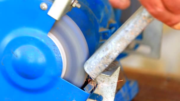 Worker grinding metal component on bench grinder — Stock Video