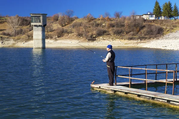 Pescador pescando en el lago azul — Foto de Stock