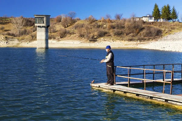 Pescador pescando en el lago azul — Foto de Stock