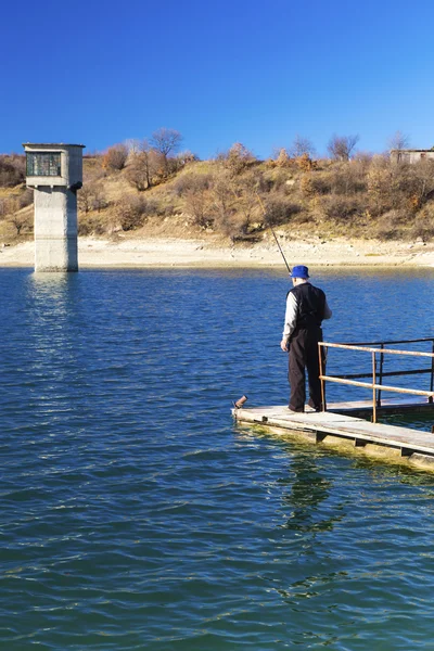 Pescador pescando en el lago azul — Foto de Stock