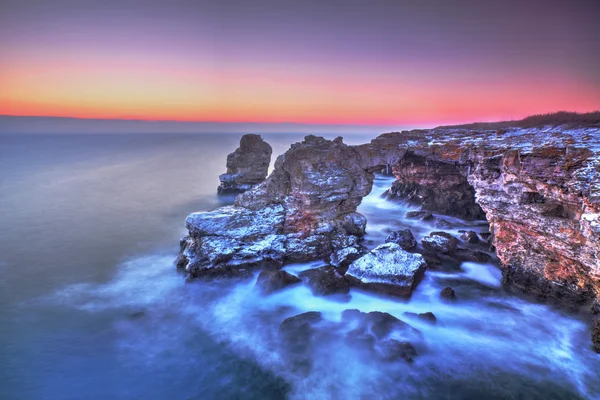 Lever de soleil coloré sur la mer et le rivage rocheux — Photo