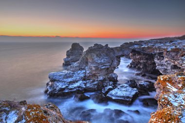 Sunrise kayalık sahil ve deniz üzerine