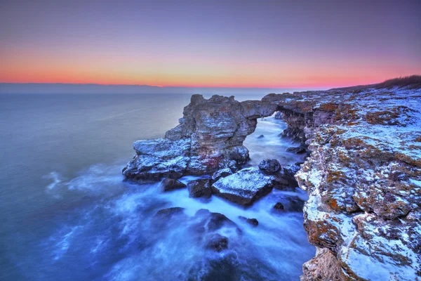 Восход солнца над морем и скалистым берегом — стоковое фото