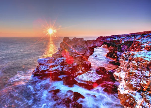 Lever de soleil coloré sur la mer et le rivage rocheux — Photo