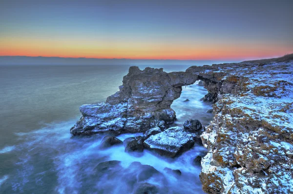 Восход солнца над морем и скалистым берегом — стоковое фото
