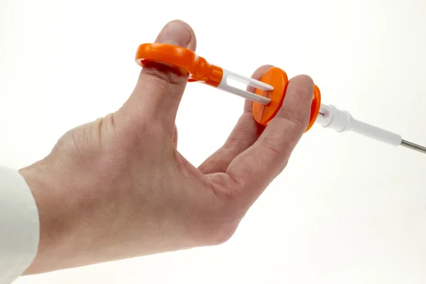 Рука, управляющая шприцом медицинского устройства — стоковое фото