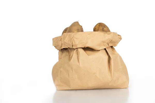 İslated üzerinde beyaz bir kağıt yıkanmamış patates çanta