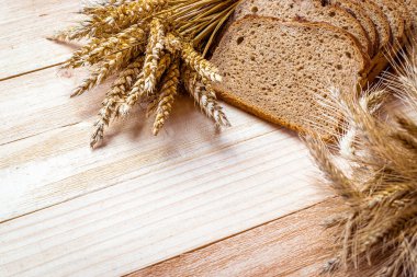 Baget ekmeği. Çavdar ekmeği ve ekmek kırıntılarıyla. Buğday tohumu kulaklı taze bir somun ekmek ya da doğal ahşap arka planda çivili bitki. Konsept - Evde Yemek Pişirme