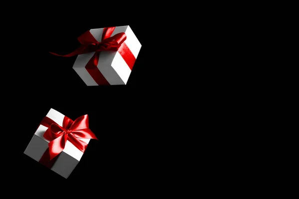折扣背景 黑色星期五的横幅 白色礼物 红色弓落在黑色背景上 带文字空间的飞行背景 — 图库照片