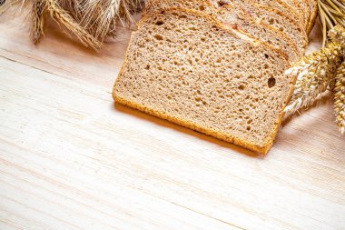 Ev yapımı ekmek. Çavdar ekmeği ve ekmek kırıntılarıyla. Buğday tohumu kulaklı taze köy ekmeği ya da doğal ahşap arka planda çivili bitki. Fırın ürün etiketi için tasarım ögesi