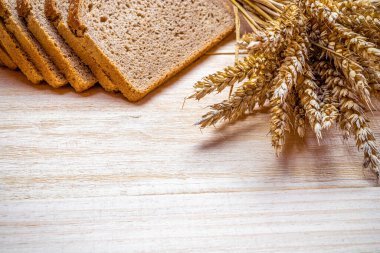 Somun ekmek. Çavdar ekmeği ve ekmek kırıntılarıyla. Buğday tohumu kulaklı taze bir somun ekmek ya da doğal ahşap arka planda çivili bitki. Biyolojik malzemeler, çok sağlıklı tohumlar.