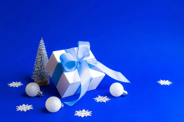 Weihnachtlicher Hintergrund Weiße Geschenkschachtel Mit Blauem Band Winterbaum Schneeflocken Und — Stockfoto