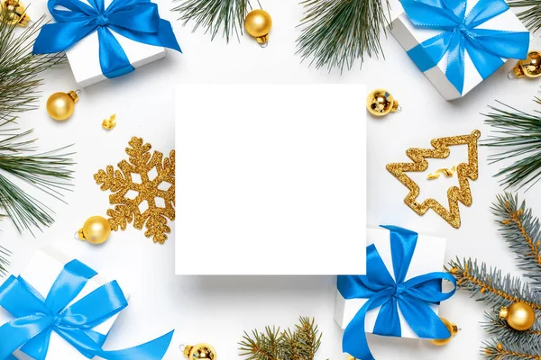 Χριστουγεννιάτικη διακόσμηση. Λευκά δώρα με μπλε φιόγκο, χρυσές μπάλες και χριστουγεννιάτικο δέντρο σε χριστουγεννιάτικη διακόσμηση σε λευκό φόντο για ευχετήρια κάρτα. Επίπεδο lay, πάνω όψη, αντιγραφή χώρου. — Φωτογραφία Αρχείου