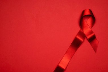 HIV günü. HIV dünyasında kırmızı arkaplanda kırmızı kurdele sembolü. Farkındalık yardımcıları ve kanser. Yaşlanma Sağlık Ay konsepti.