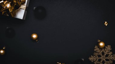 2021 Beyaz hediye kutusunda altın kurdele, yeni yıl baloları ve parlak ışık çelenkleri var. Siyah arka planda tebrik kartı için. Metnin için dekorasyon ve kopyalama alanı