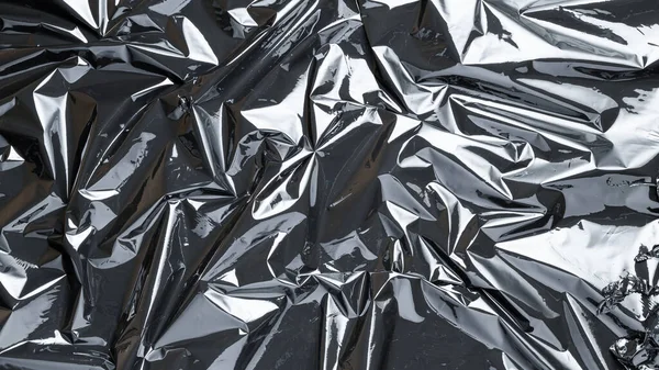 Plastic wrap. Black shiny film bag pattern. Transparent dark cellophane texture. Creative crumpled background