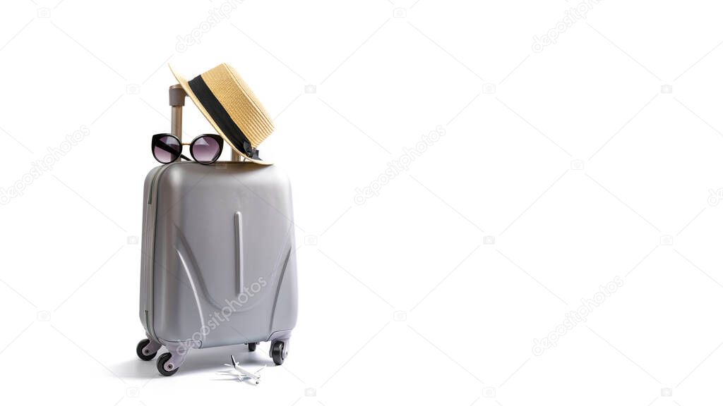 Summer time. Travel accessories with suitcase, straw hat, palm leaves in minimal trip vacation concept isolated on white background. Exotic tropical beach with copy space.