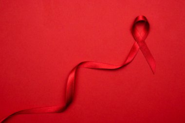 HIV günü. HIV dünyasında kırmızı arkaplanda kırmızı kurdele sembolü. Farkındalık yardımcıları ve kanser. Yaşlanma Sağlık Ay konsepti