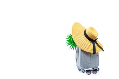 Deniz arka planı. Bavullu seyahat aksesuarları, hasır şapka, beyaz arka planda izole edilmiş minimum tatil konseptinde palmiye yaprakları. Kopyalama alanı olan sakin sahil sahnesi.