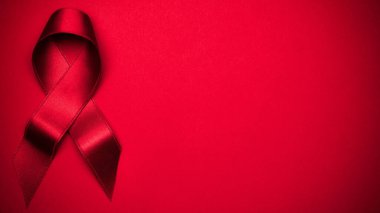 HIV günü. HIV dünyasında kırmızı arkaplanda kırmızı kurdele sembolü. Farkındalık yardımcıları ve kanser. Yaşlanma Sağlık Ay konsepti
