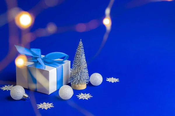 冬の販売 グリーティングカードのための青の背景に青いリボン 冬の木 雪の結晶とクリスマスの組成物のシルバーボールとホワイトギフトボックス クリスマス 新年のコンセプト — ストック写真