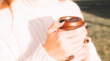 Çay içen kadın. Güneşin altında dışarıda oturan mutlu, genç bir kız. Bir fincan sıcak içecek.