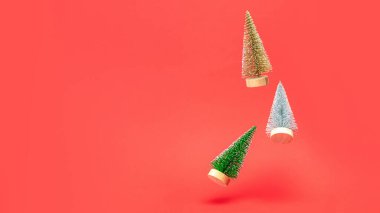 Xmas çelengi. Gümüş, altın ve yeşil kış ağaçları düşer ve Noel kompozisyonunda parlak ışıklar kutlama kartı için koyu kırmızı arka planda olur. Noel, kış, yeni yıl konsepti