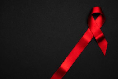 HIV desteği. HIV dünyasında siyah zemin üzerinde kırmızı kurdele sembolü. Farkındalık yardımcıları ve kanser. Yaşlanma Sağlık Ay konsepti