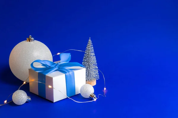 クリスマスの装飾は孤立した グリーティングカードのための青い背景に青いリボン 冬の木 雪の結晶とクリスマスの組成物のシルバーボールとホワイトギフト 冬のお祝いの組成 コピースペース — ストック写真