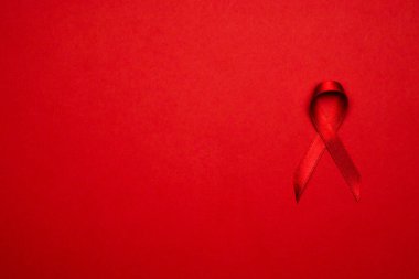 Göğüs kanseri olan kadın. HIV dünyasında kırmızı arkaplanda kırmızı kurdele sembolü. Farkındalık yardımcıları ve kanser. Sağlık ve Tıp Konsepti