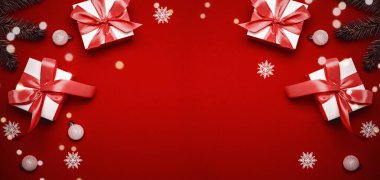 Sürpriz kutu. Kırmızı kurdeleli beyaz hediyeler, kırmızı toplar ve kostüm süslemeli parlak ışıklar tebrik kartı için kırmızımsı arka planda. Düz konum, üst görünüm, kopyalama alanı